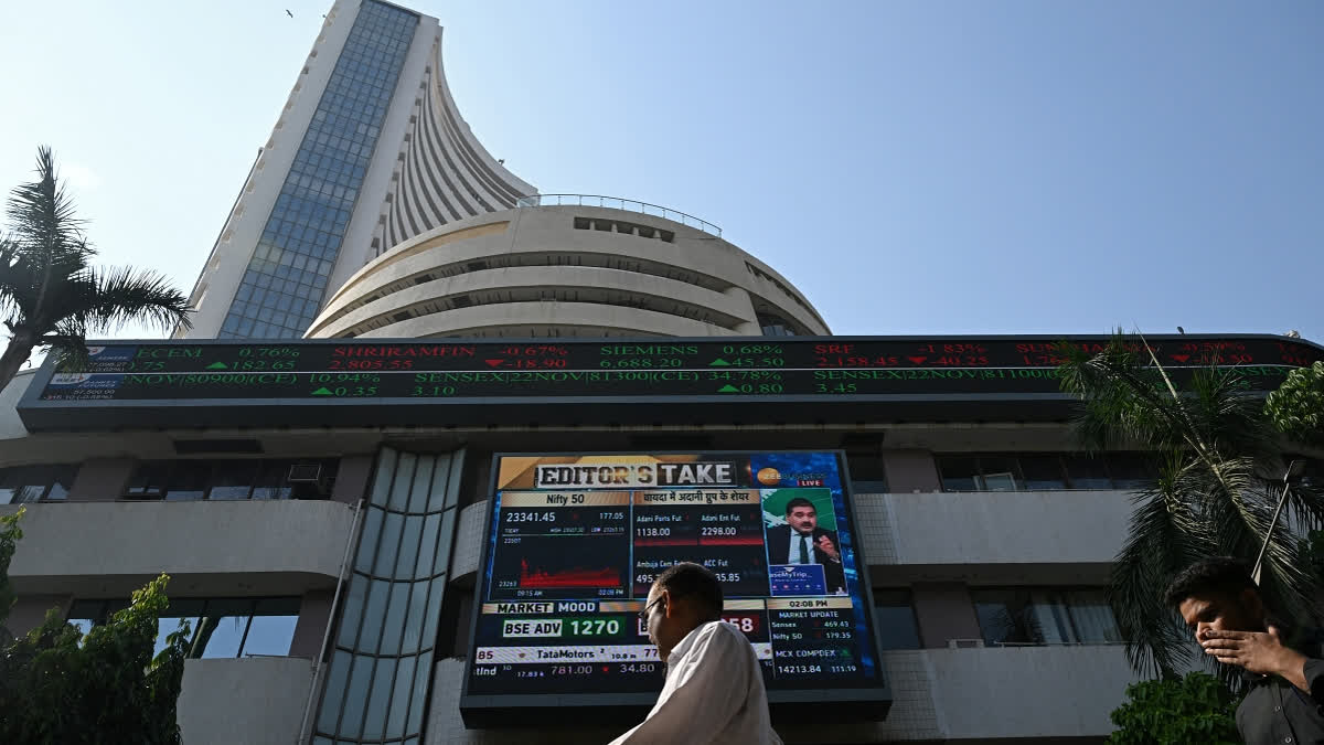 Pedestrians walk past a digital broadcast on the facade of Bombay Stock Exchange (BSE) in Mumbai.