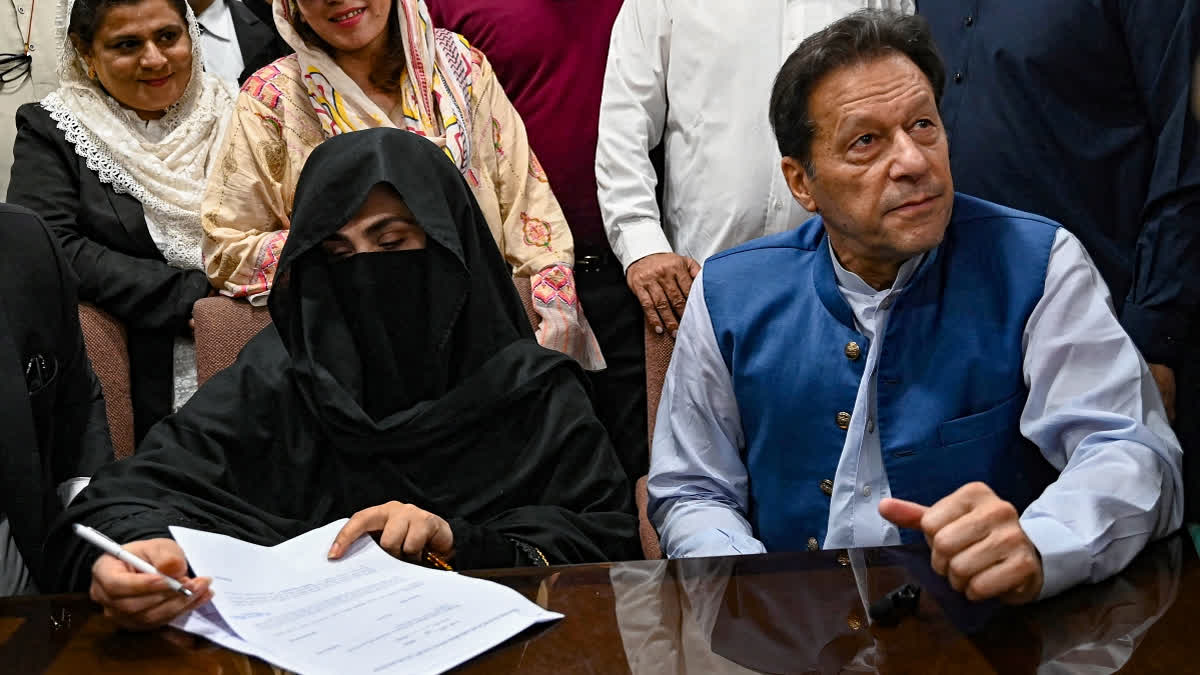 Pakistan's former Prime Minister, Imran Khan (R) along with his wife Bushra Bibi (L) looks on as he signs surety bonds for bail in various cases, at a registrar office in the High court, in Lahore on July 17, 2023.