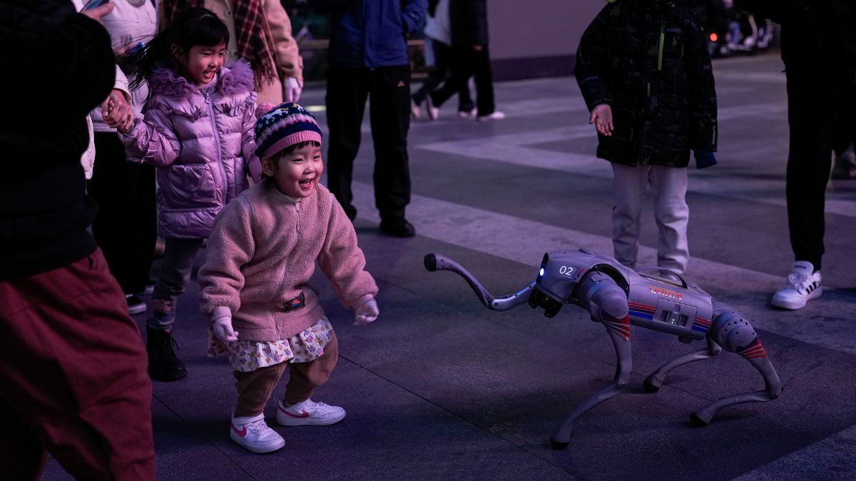 A child reacts to an Unitree Go2 intelligent side-follow robot during a performance at a shopping district in Beijing