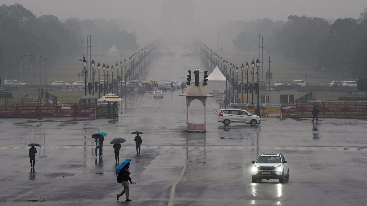 Vehicles move amid rain at Vijay Chowk, in New Delhi, Friday, Dec. 27, 2024.