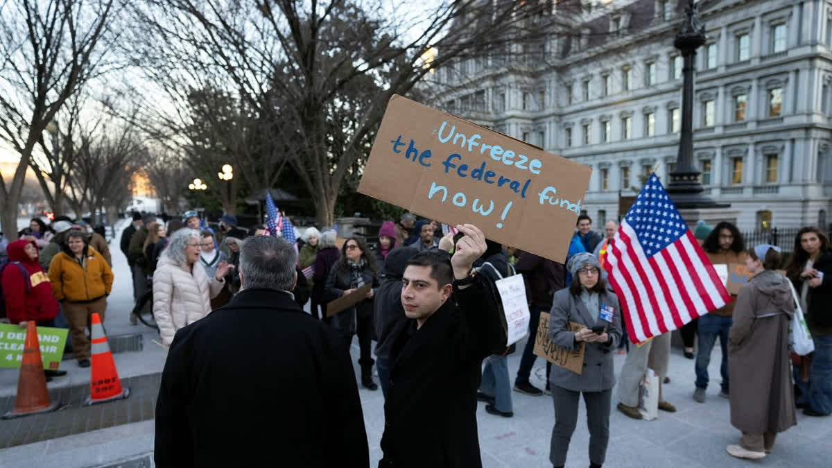 People protest against a funding freeze of federal grants and loans following a push from President Donald Trump to pause federal funding near to the White House in Washington, Tuesday, Jan. 28, 2025.