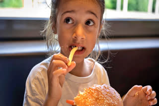 Girl eating a burger and fries