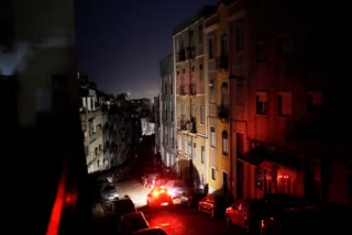 A car drives down an unlit street in Lisbon, during a nationwide power outage, Monday night, April 28, 2025.