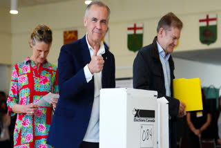 Canadian Prime Minister and Liberal leader Mark Carney, alongside his wife Diana Fox Carney (L), gives a thumbs up after casting his ballot a polling station during the federal election in Ottawa, Canada on April 28, 2025.