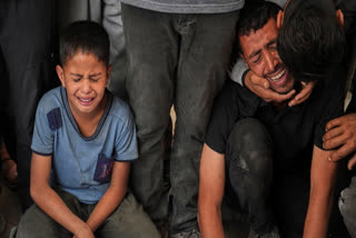 Relatives react as they mourn over the body of a loved one killed, along with others, in Israeli strikes on the Gaza Strip, at Al-Shifa Hospital in Gaza City, Saturday, June 28, 2025.