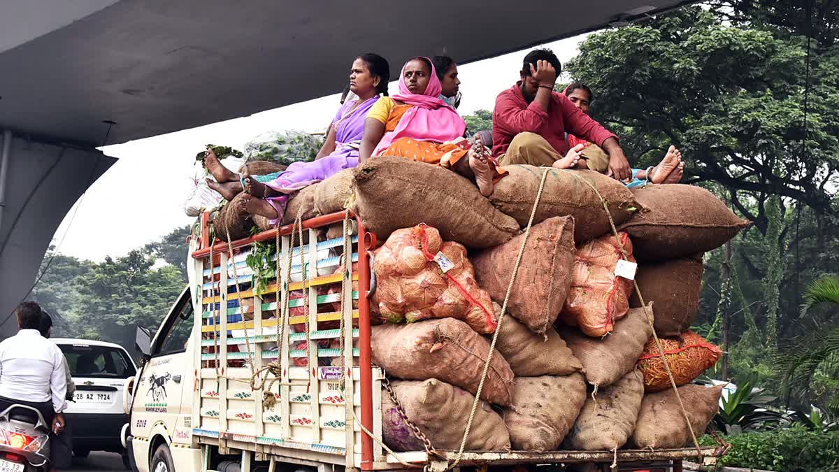 People sitting on an overloaded tempo with vegetables in Hyderabad