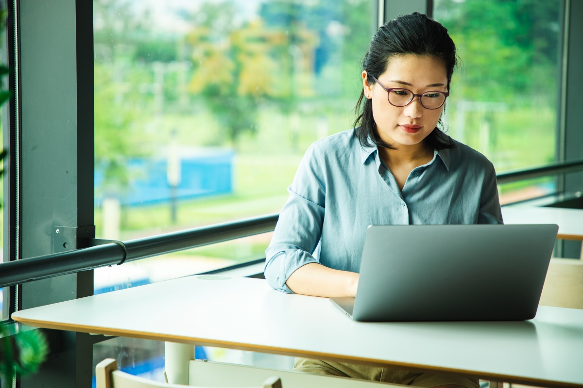 Woman working on a laptop by the window