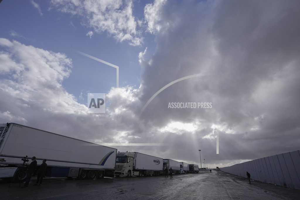 Trucks carrying humanitarian aid line up to cross Rafah crossing port, Egypt