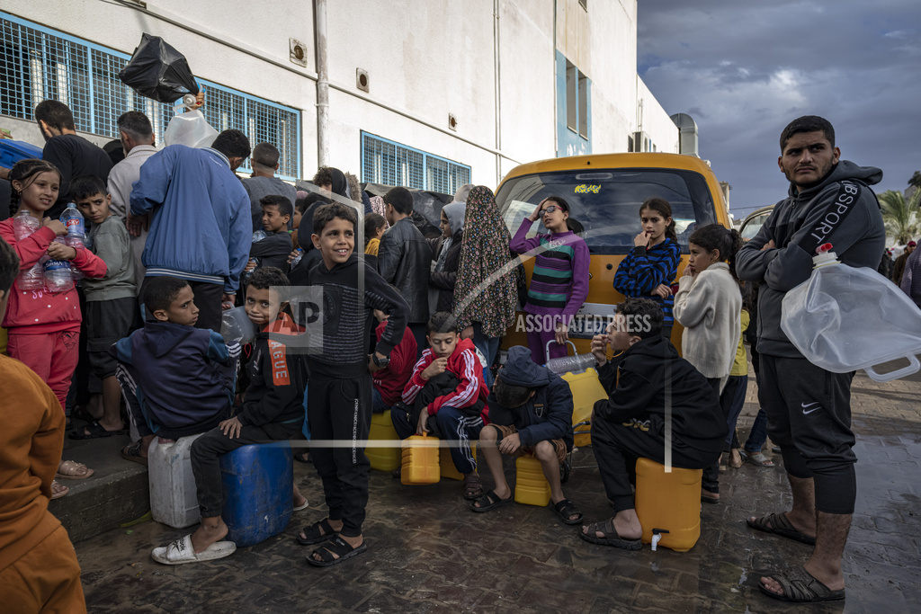 Palestinians displaced by the Israeli bombardment of the Gaza Strip queue for water