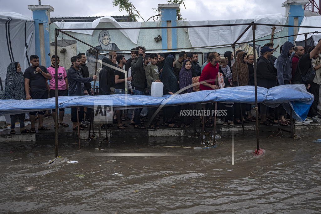 Palestinians displaced by the Israeli bombardment of the Gaza Strip seek cover from a winter rainfall