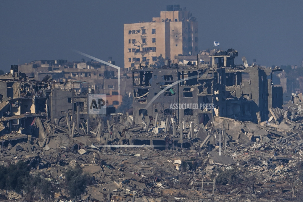 Israeli flags stand on the top of destroyed buildings in the Gaza Strip