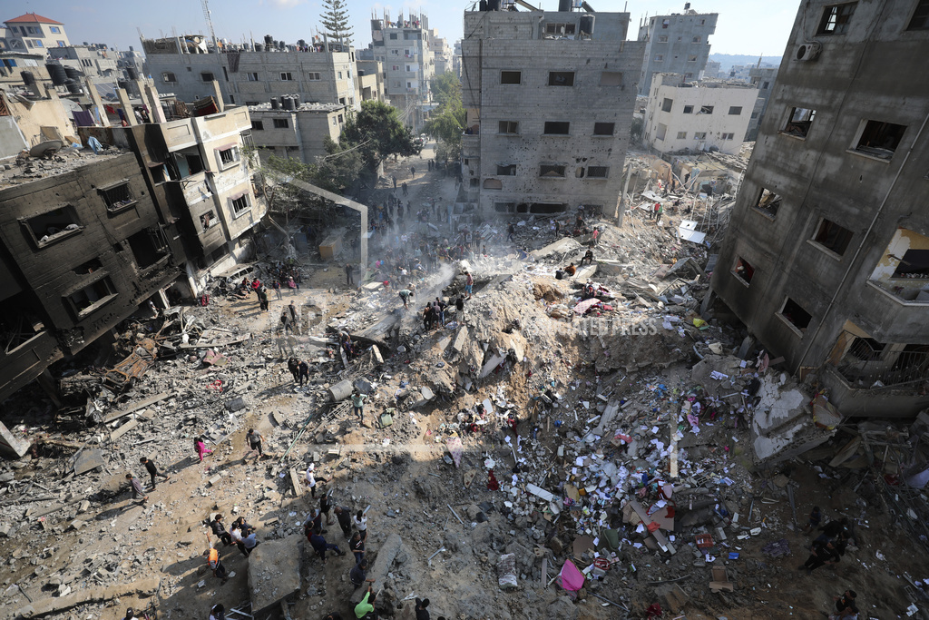 Palestinians look at destruction after an Israeli strike on the Gaza Strip