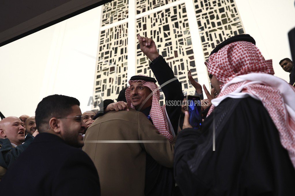 Members of the Saudi Arabia delegation react as the Bureau International des Expositions, or BIE, announces the vote