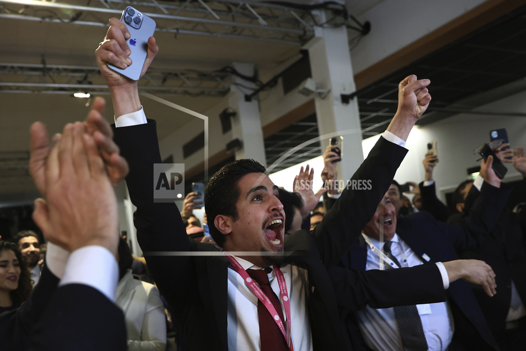 Members of the Saudi Arabia delegation react as the Bureau International des Expositions, or BIE, announces the vote