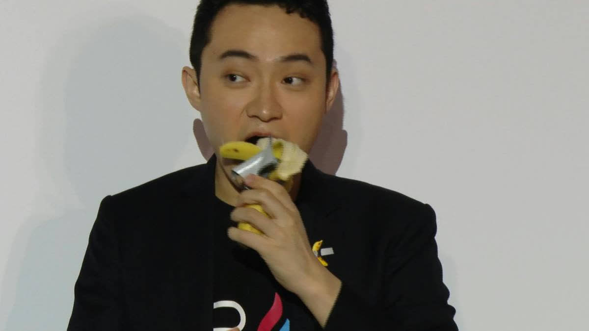 Crypto entrepreneur Justin Sun eats the banana from Maurizio Cattelan's 'Comedian' artwork at a press conference, comparing it to NFT art and blockchain technology.