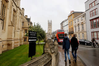 FILE - People walk around Oxford University's campus on Sept. 3, 2017, in Oxford, England.