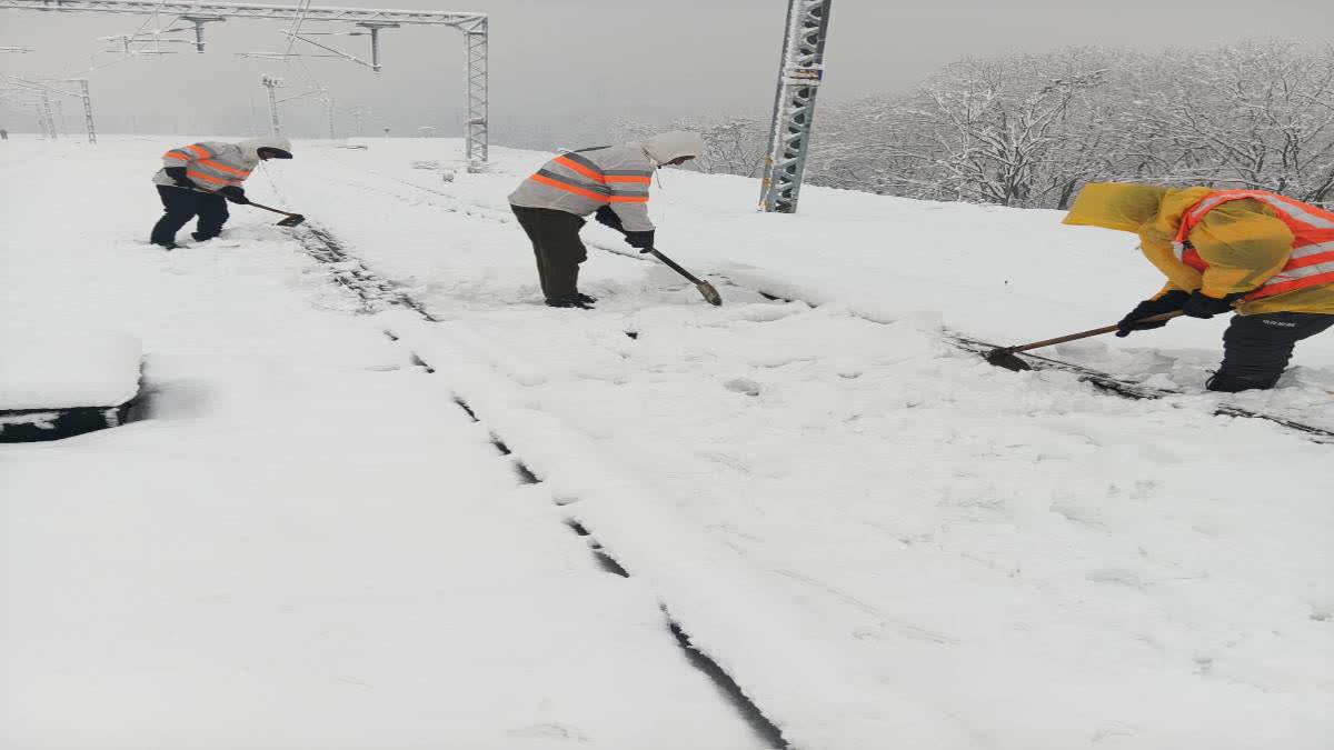 Workers clearing snow from track