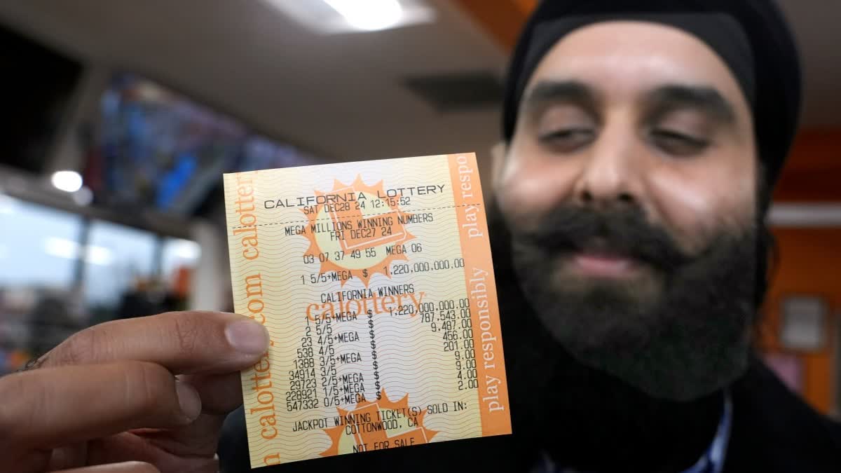 Ishar Gill holds up a copy of the Mega Millions lotto ticket worth an estimated $1.22 billion at his family's store in Cottonwood, Calif., Saturday, Dec. 28, 2024