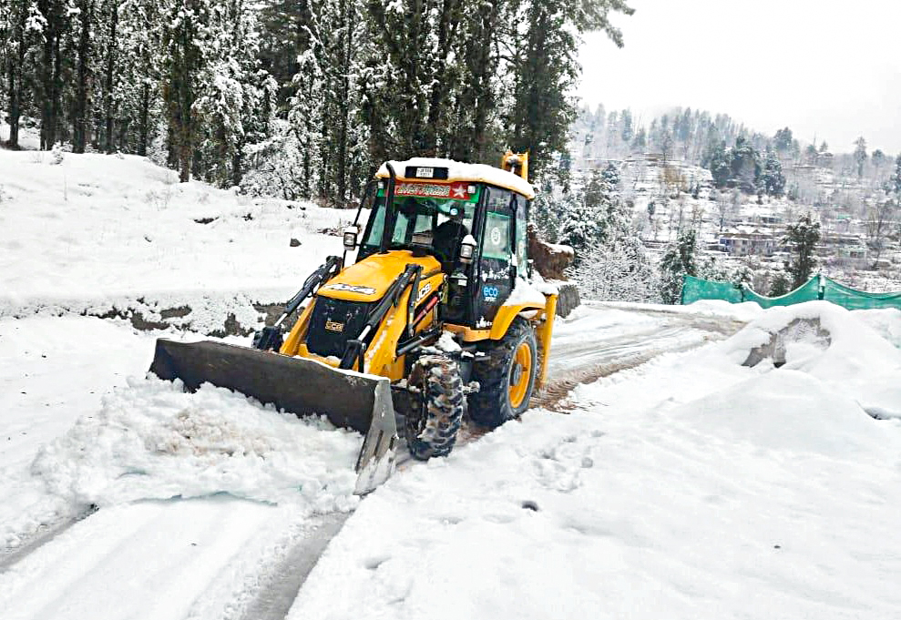 A snow-clearance machine clears a path following heavy snowfall for safe commutation, on Saturday.