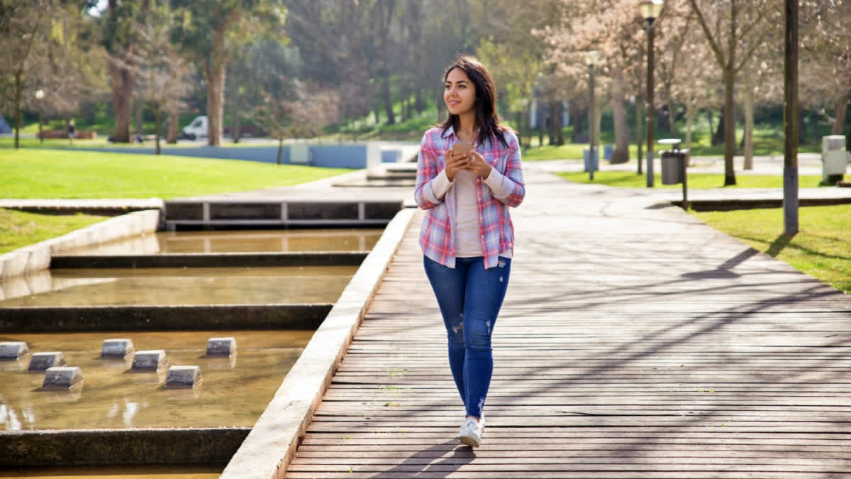 Woman walking down a green park