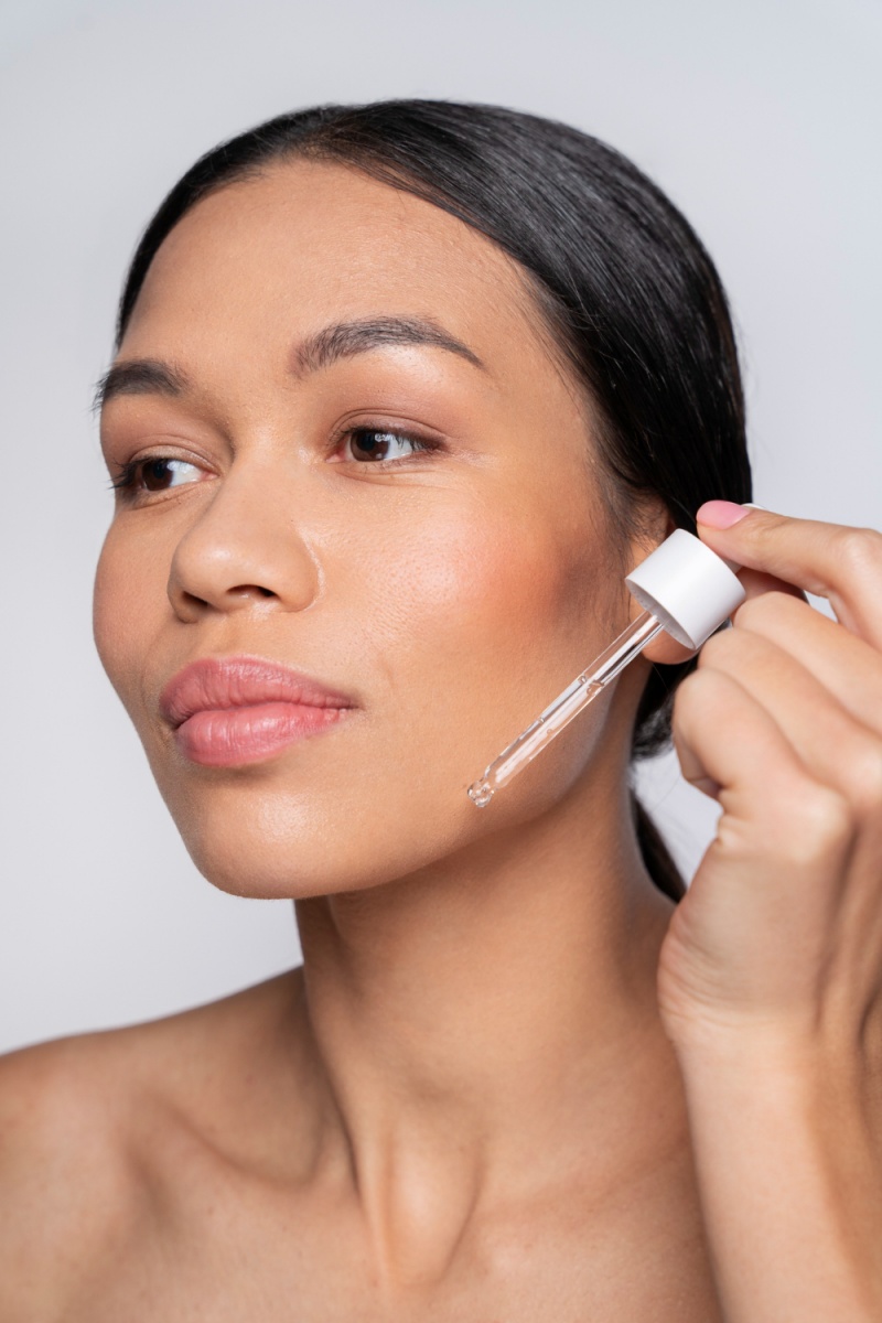 Woman applying serum to her face