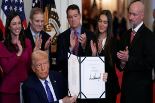 President Donald Trump holds the document after signing the Laken Riley Act during an event in the East Room of the White House, Wednesday, Jan. 29, 2025, in Washington.