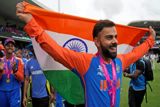 India's Virat Kohli carries the Indian national flag as he celebrates after India won the ICC Men's T20 World Cup final cricket match against South Africa at Kensington Oval in Bridgetown, Barbados, Saturday, June 29, 2024.