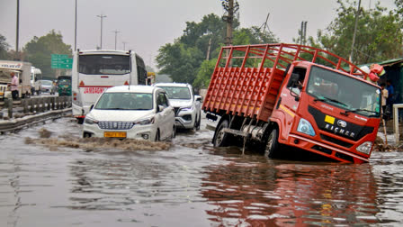 Vehicles wade through the waterlogged Delhi-Gurugram Expressway service road after heavy rains, in Gurugram on Friday.