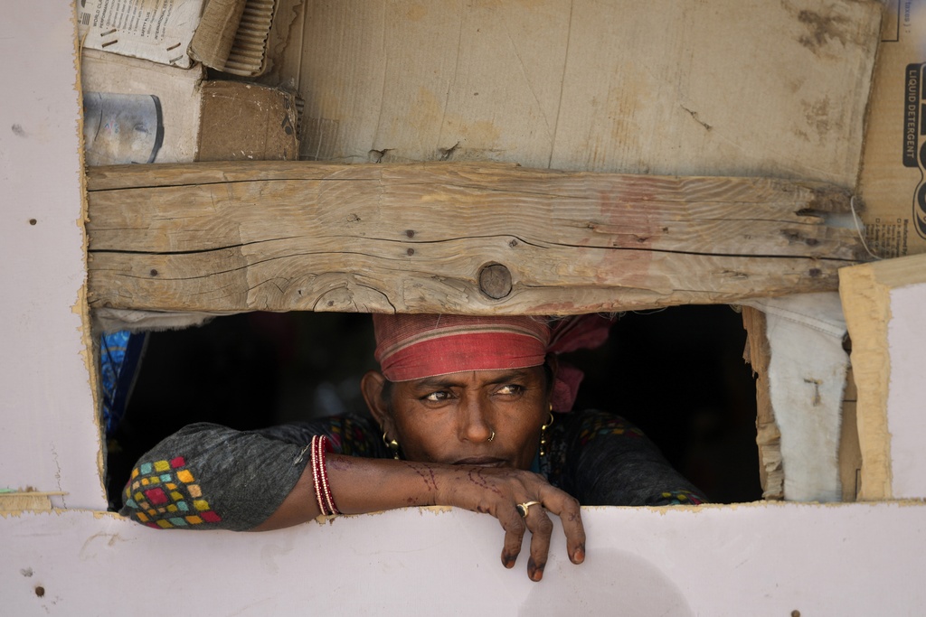 Waste picker Salmaa Shekh looks outside a temporary shelter during a heat wave at a garbage dump