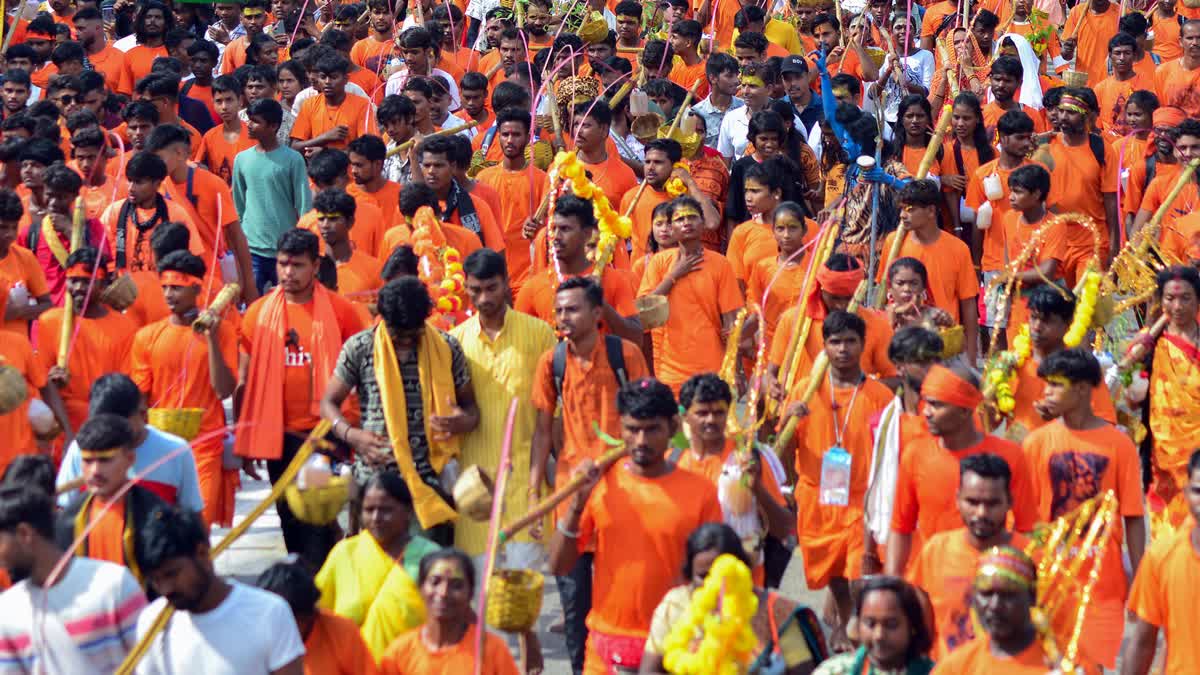 Kanwariyas (Shiv devotees) carry pots filled with water collected from Narmada river during the annual Kanwar Yatra, in Jabalpur on Monday, July 30, 2024