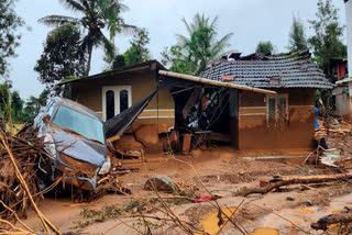 A damaged car and a house after landslides hit hilly villages in Wayanad district, Kerala, Tuesday, July 30, 2024.