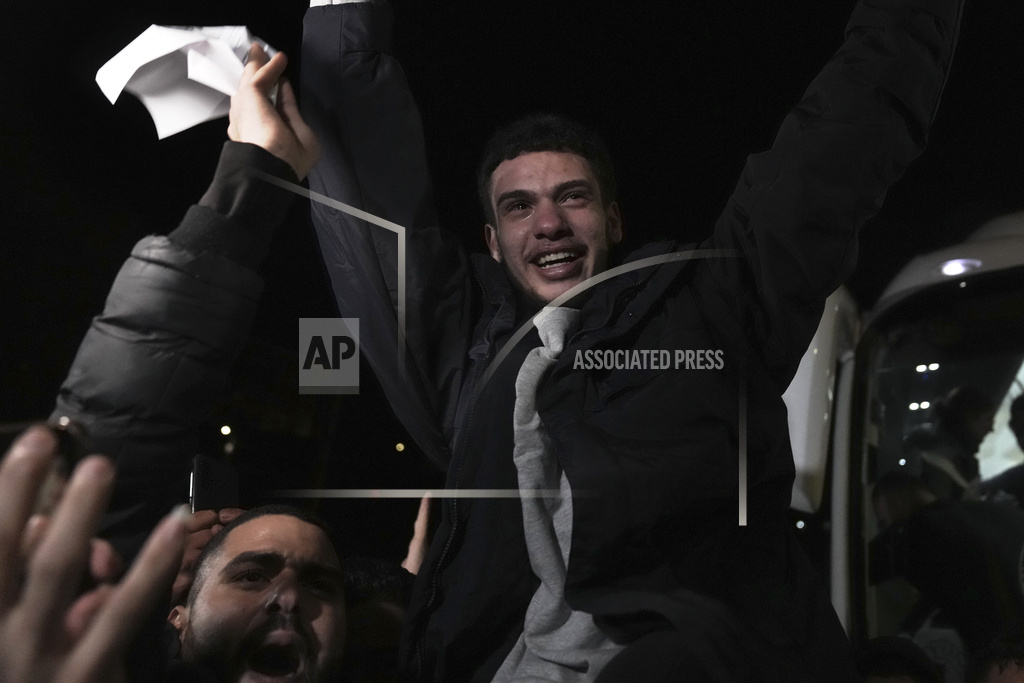 A man smiles as he is welcomed after being released from prison by Israel