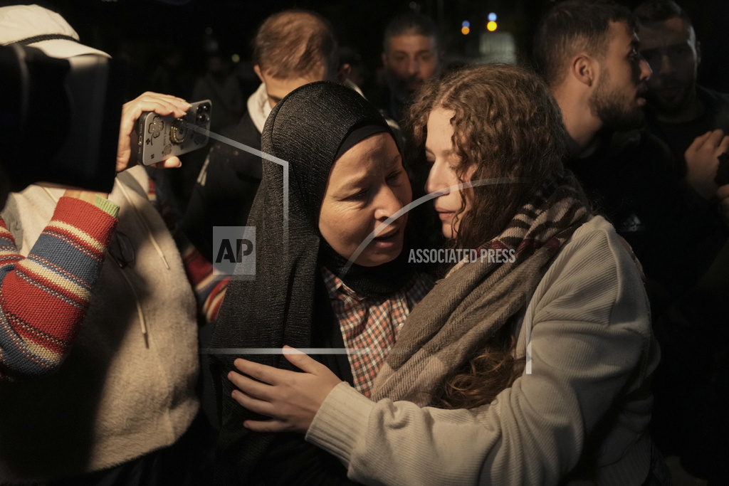 Palestinian activist Ahed Tamimi, center is hugged by a woman after she was released from prison by Israel