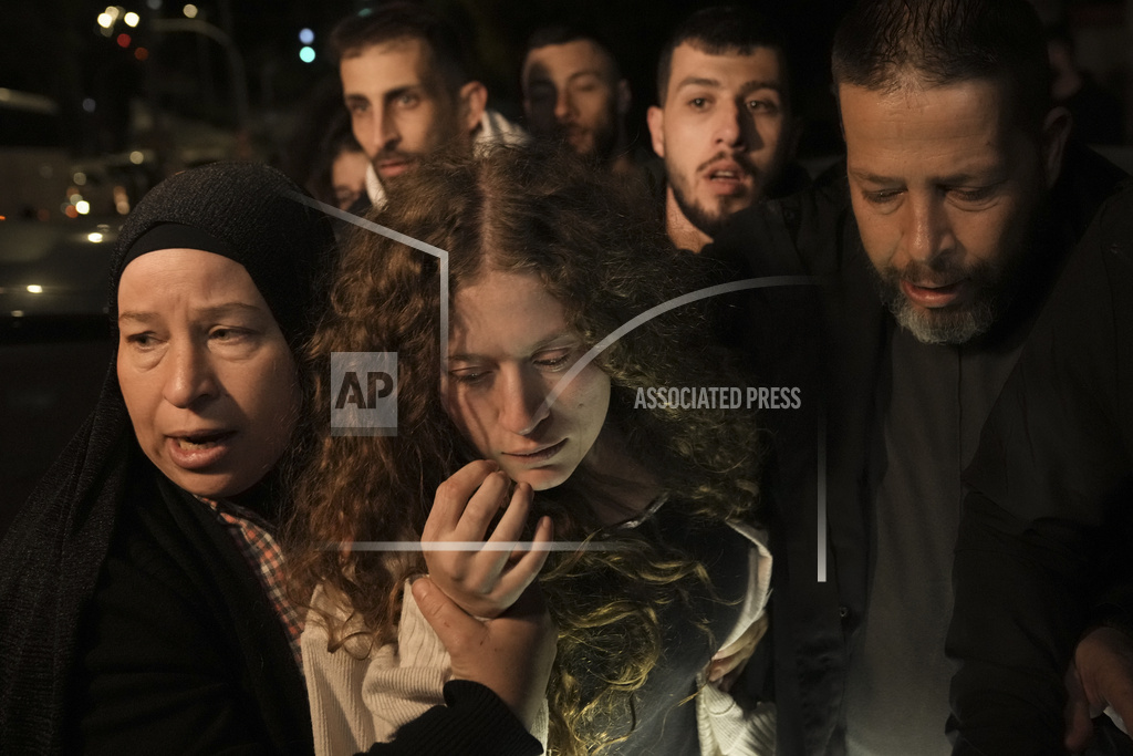 Palestinian activist Ahed Tamimi, center is supported by her mother after she was released from prison by Israel