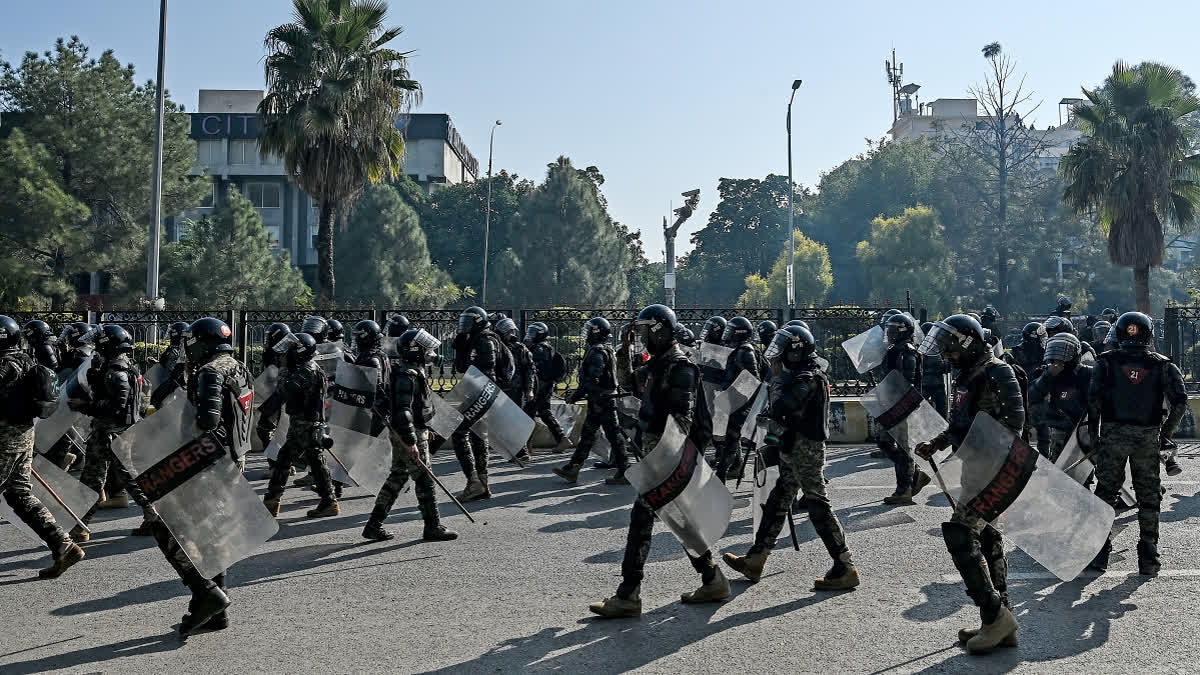 Paramilitary soldiers march along a street leading to the Red Zone area during a protest by the supporters of the Pakistan Tehreek-e-Insaf (PTI) party demanding the release of former prime minister Imran Khan, at the Red Zone area in Islamabad on November 26, 2024.