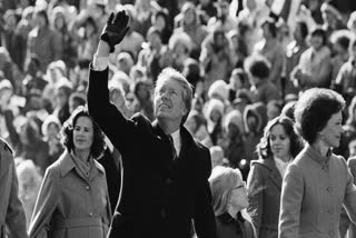 FILE - President Jimmy Carter waves to the crowd while walking with his wife Rosalynn and their daughter Amy along Pennsylvania Avenue from the Capitol to the White House following his inauguration, Jan. 20, 1977, in Washington.