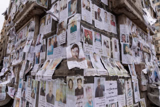 Portraits of missing people whose families say they were taken by the Assad regime are plastered across a monument in Damascus, Syria, Saturday, Dec. 28, 2024