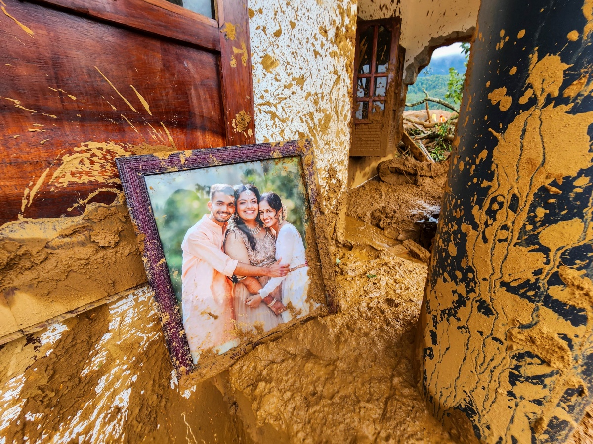 A framed photograph lies partially covered in mud at a damaged house in Wayanad. There was no immediate information available on the people in the picture.