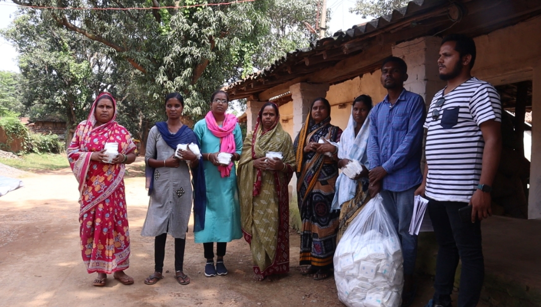 Members of an organisation distrubuting sanitary pads to women.