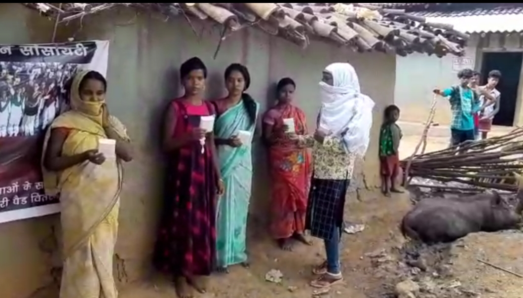 Members of an organisation distrubuting sanitary pads to women.