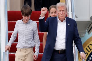 President Donald Trump, front right, gestures as he walks down the stairs of Air Force One with his grandchildren, Spencer, left, and Chloe, back center, upon his arrival at Joint Base Andrews, Md., Tuesday, July 29, 2025.