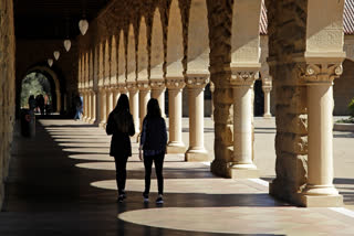 Students walk on the Stanford University campus on March 14, 2019, in Stanford, Calif.