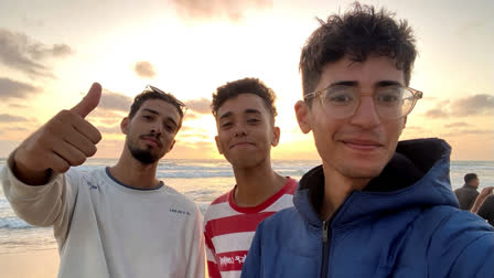 In this undated photo provided by Helmi Hirez, Mohamed (Medo) Halimy, left, and twin brothers Mohammed Hirez, center, and Helmi Hirez, right, stand on a beach in Gaza.