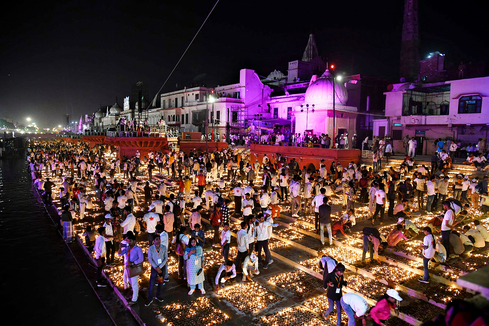 Devotees light earthen lamps on the banks of Saryu river during the Deepotsav celebrations, in Ayodhya on Wednesday.