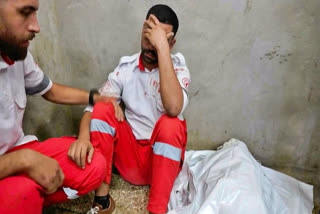 In this image made from an Associated Press video, medic Abed Al Aziz Bardini mourns next to the body of his mother on Wednesday, Oct. 30, 2024, in Deir al-Balah on the Gaza Strip.