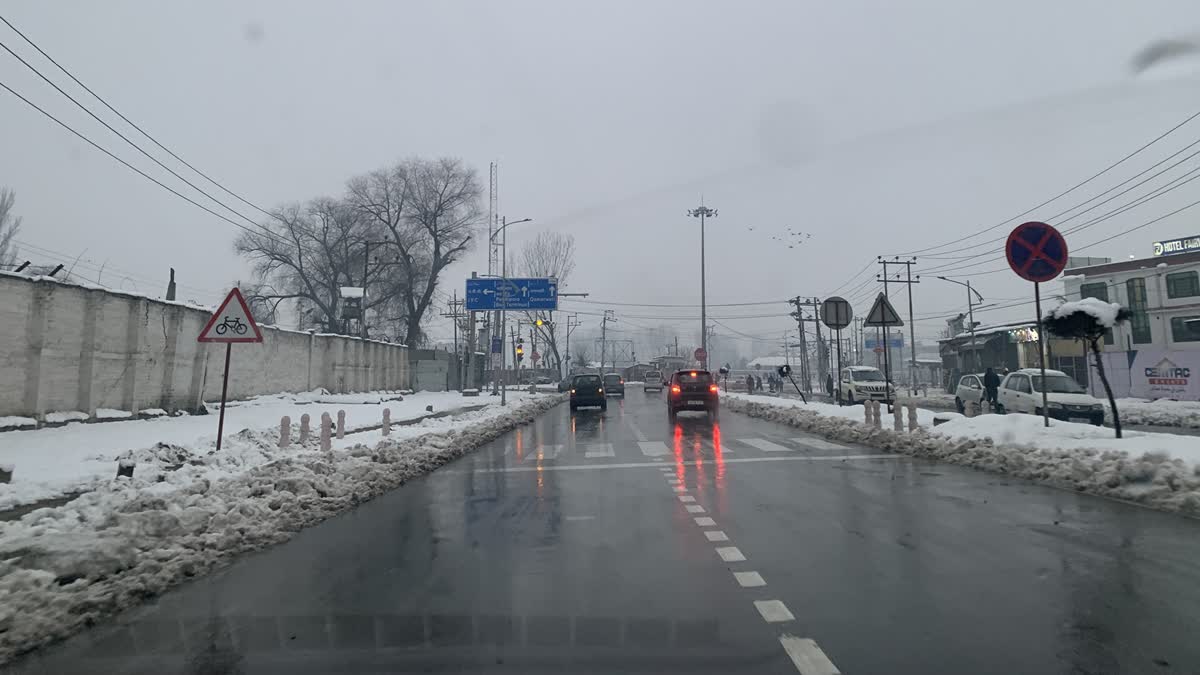 Cars plying on a road after fresh snowfall in Kashmir