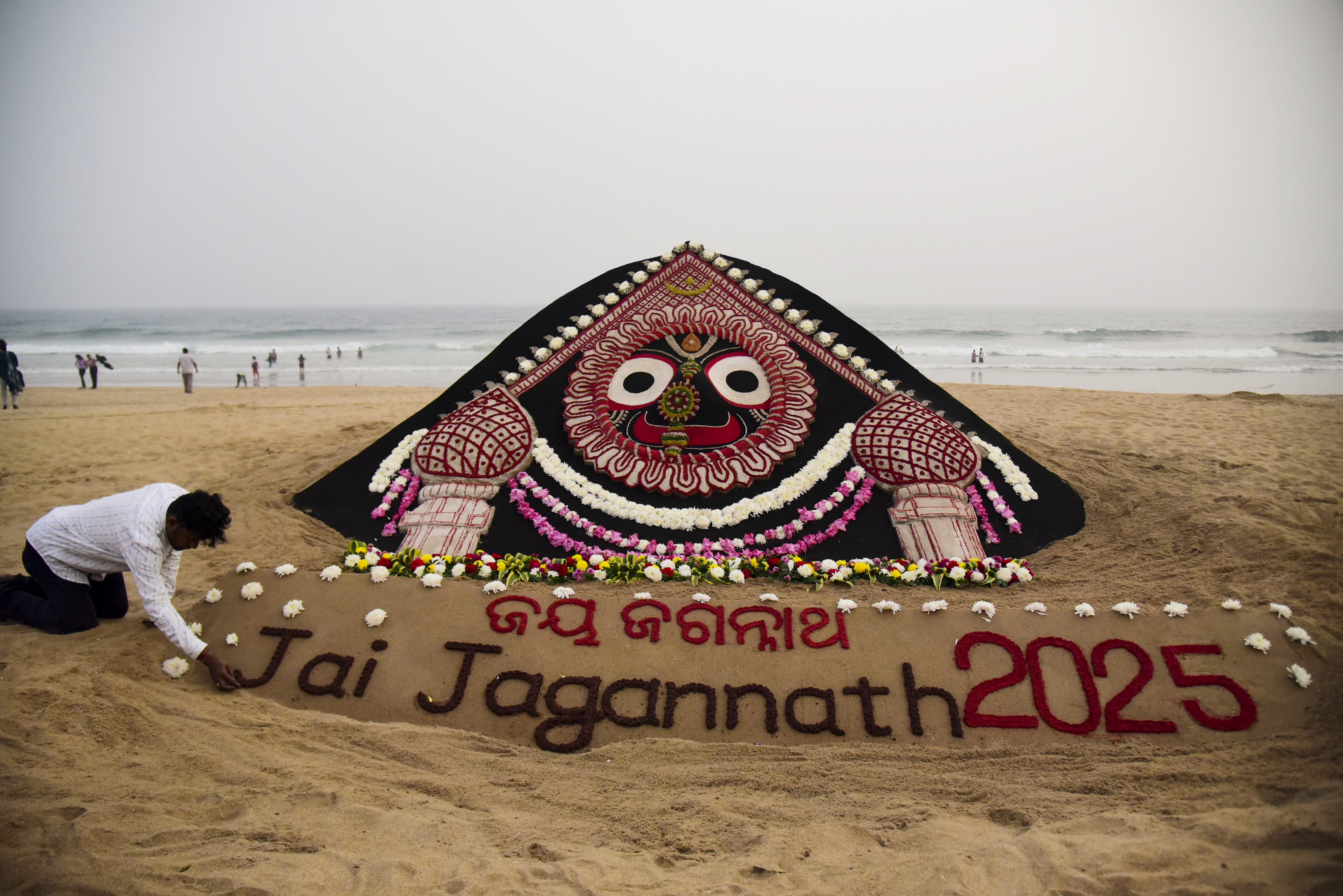 Puri: Sand artist Sudarshan Pattnaik creates a sand sculpture of Lord Jagannath's 'padma besha' on New Year's eve, at Puri beach, Odisha, Tuesday, Dec. 31, 2024.