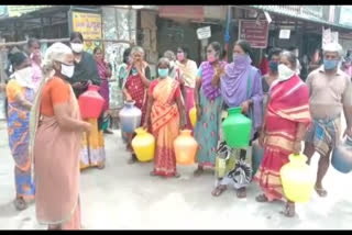 Women's road stir with empty pots for proper drinking water supply