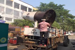 मशीन से पानी का छिड़काव करते कर्मचारी.