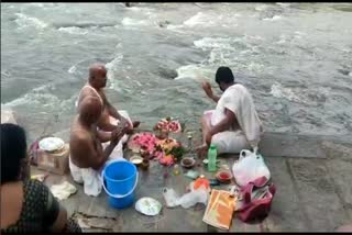   people throwing ash to river  